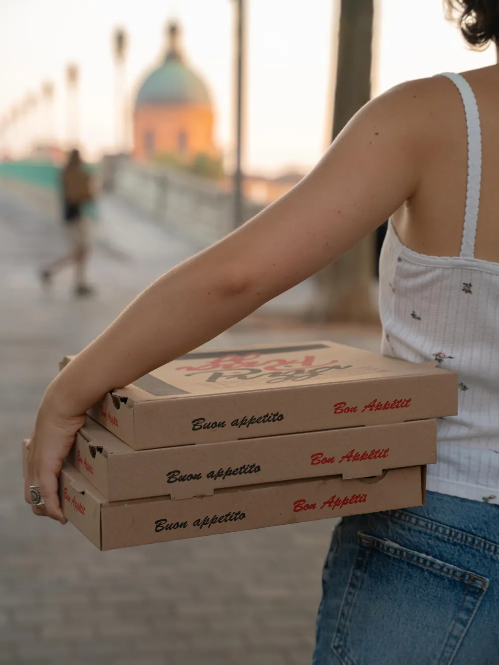 Une pile de boîtes Buon appetito sous le bras